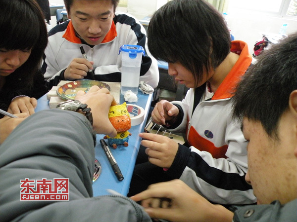 同學(xué)們?cè)诶蠋煹闹笇?dǎo)下制作心愿卡作品。
