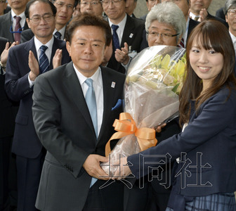 12月18日，高票當選東京都新知事的豬瀨直樹正式到任。圖為豬瀨從政府職員手中接過花束。(共同社)