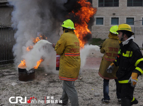 兩名志愿者在消防員的指揮下滅火。（攝影：張瑾） 