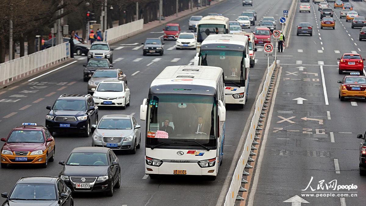 沒(méi)有封路及警車(chē)帶道，重慶代表團(tuán)接送車(chē)有序通過(guò)長(zhǎng)安街。吉羽/攝影