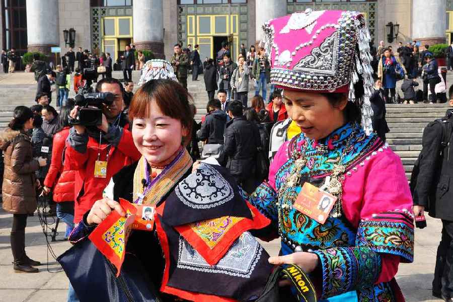 云南代表團(tuán)的兩位女代表在為記者展示她們帶來的民族特色手工藝品。 人民網(wǎng)記者 馬麗婭 攝
